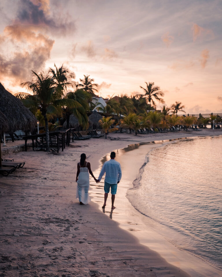 Couple holding hands at sunset on a beach in Curacao