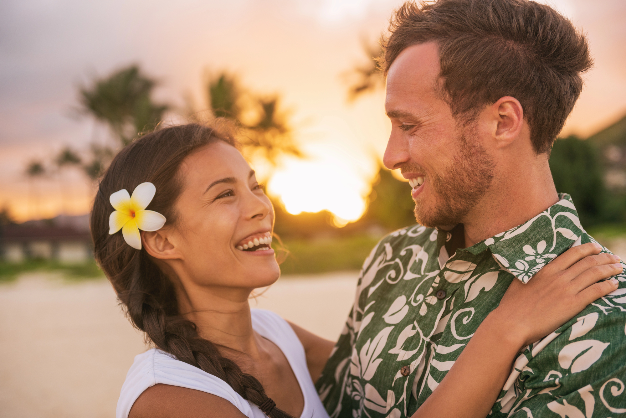 Happy couple on romantic sunset beach vacation in Hawaii