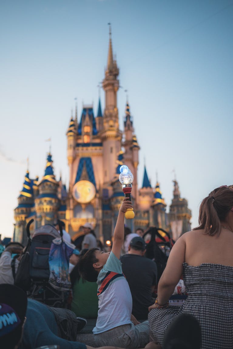 Families enjoy a magical evening at Cinderella Castle, surrounded by iconic architecture and lively entertainment.